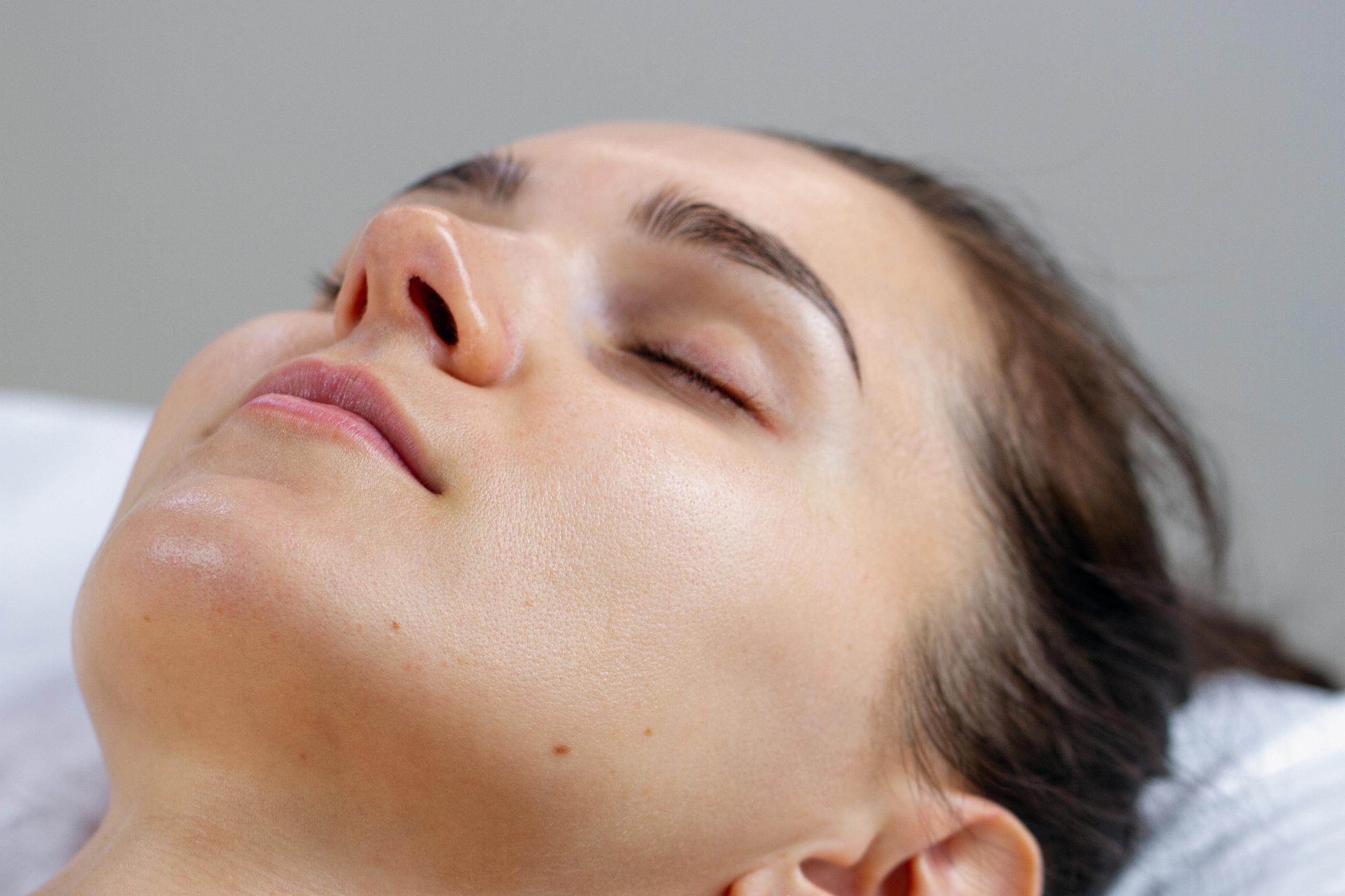 Close-up of a woman with closed eyes, looking relaxed.
