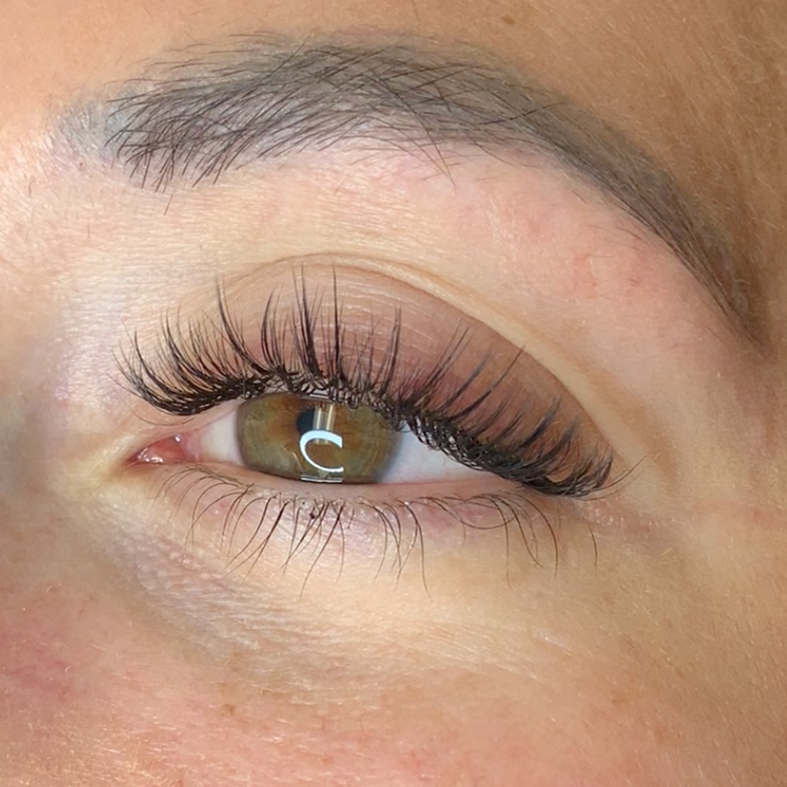 Close-up of an eye with long, dark, voluminous eyelash extensions.