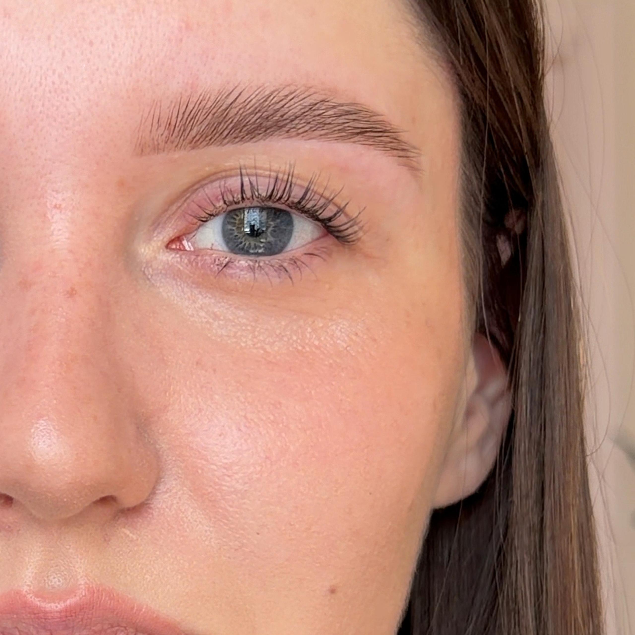 Client with lifted, feathery eyebrows after brow lamination.