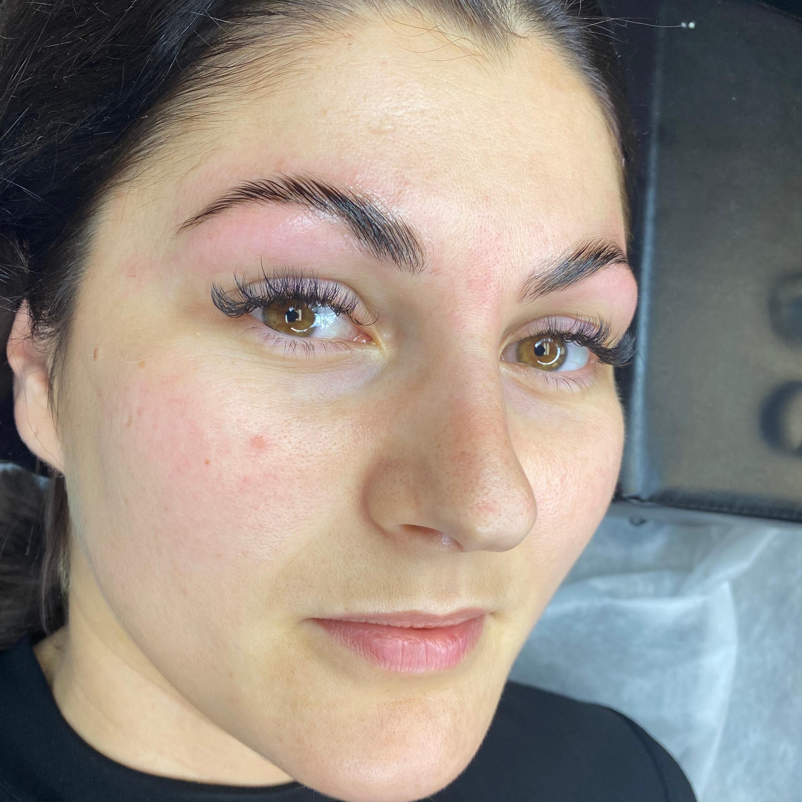 Woman with dark hair, freshly done eyebrows and eyelash extensions