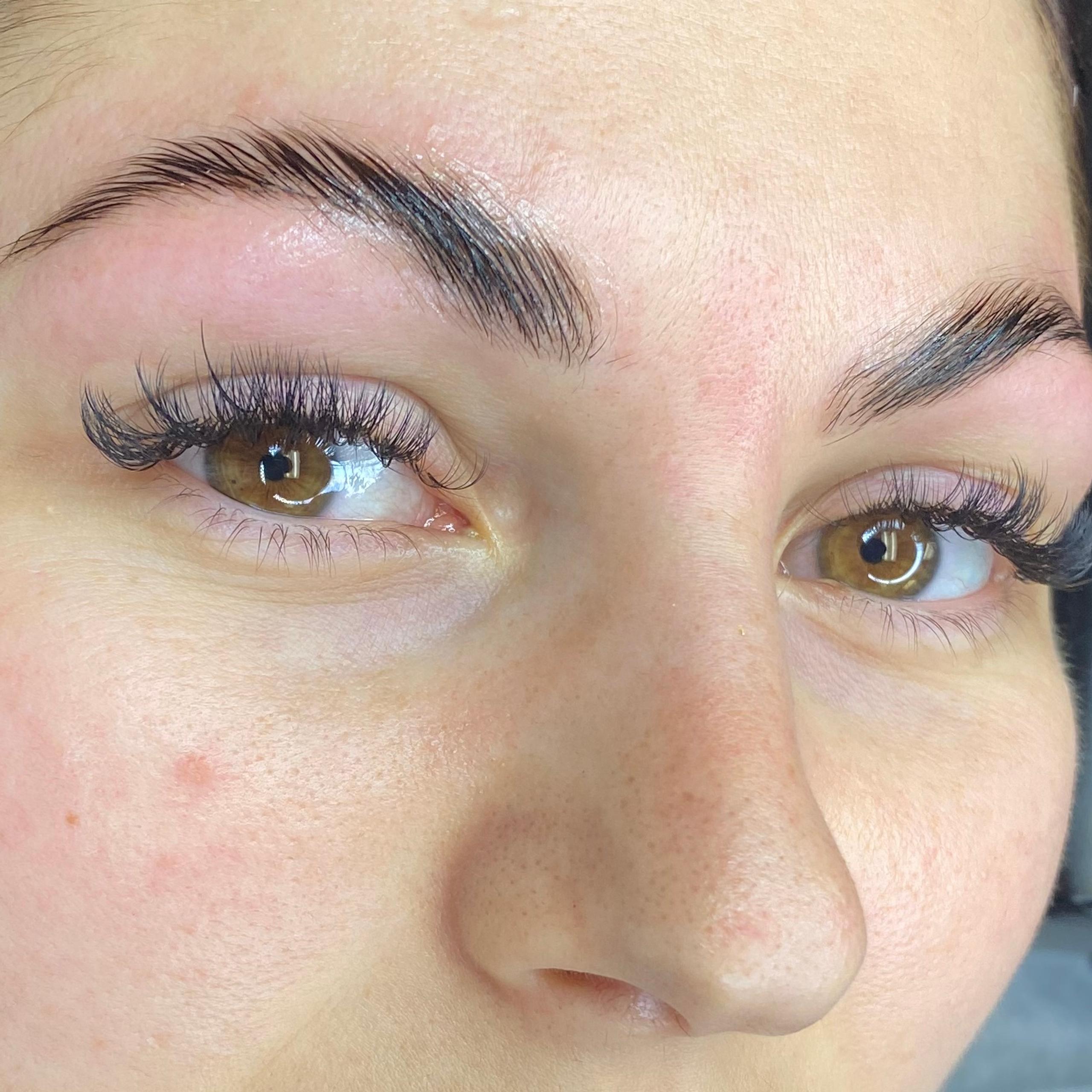 Woman with dark hair, freshly done eyebrows and eyelash extensions