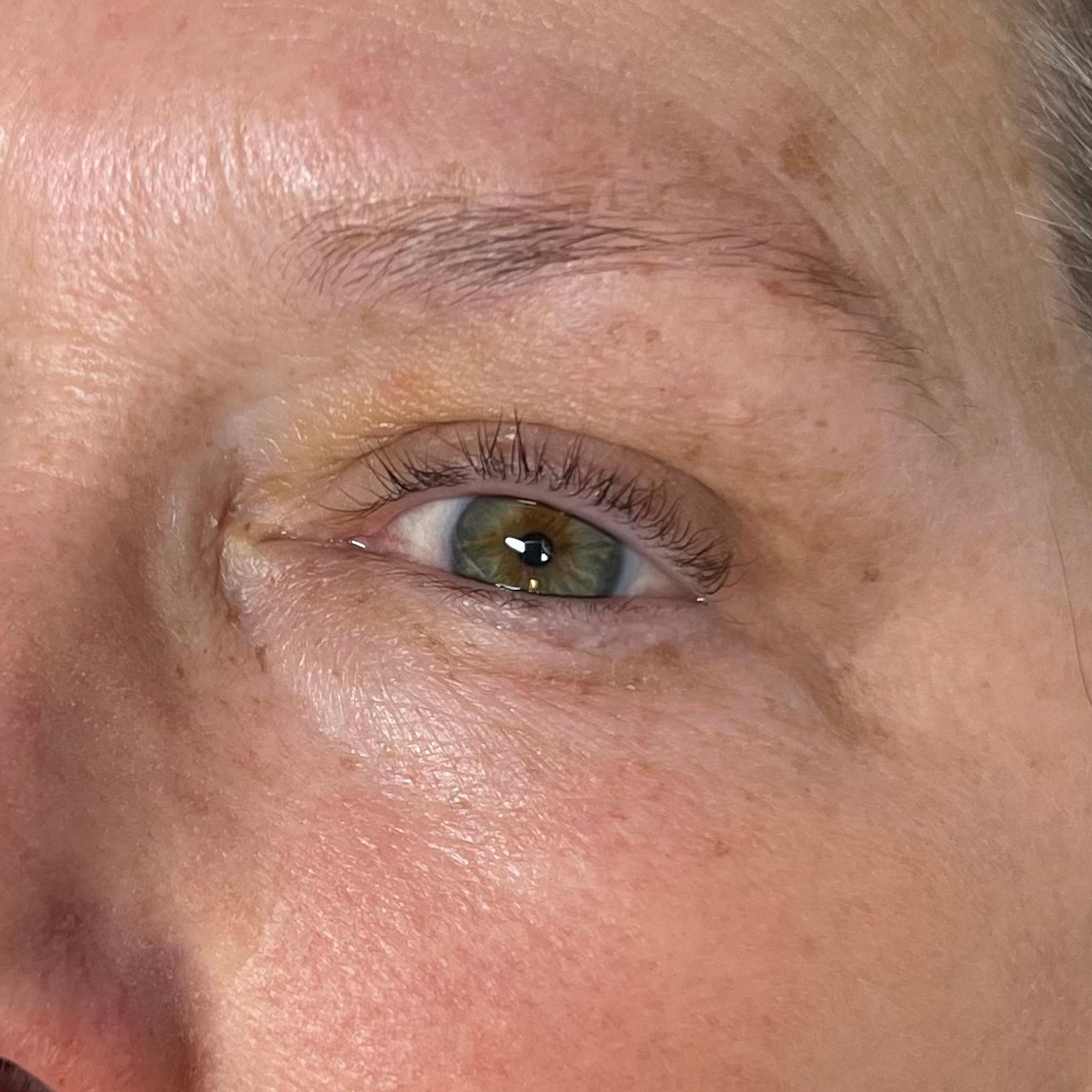 Close-up of a woman with green eyes, natural eyelashes and eyebrows