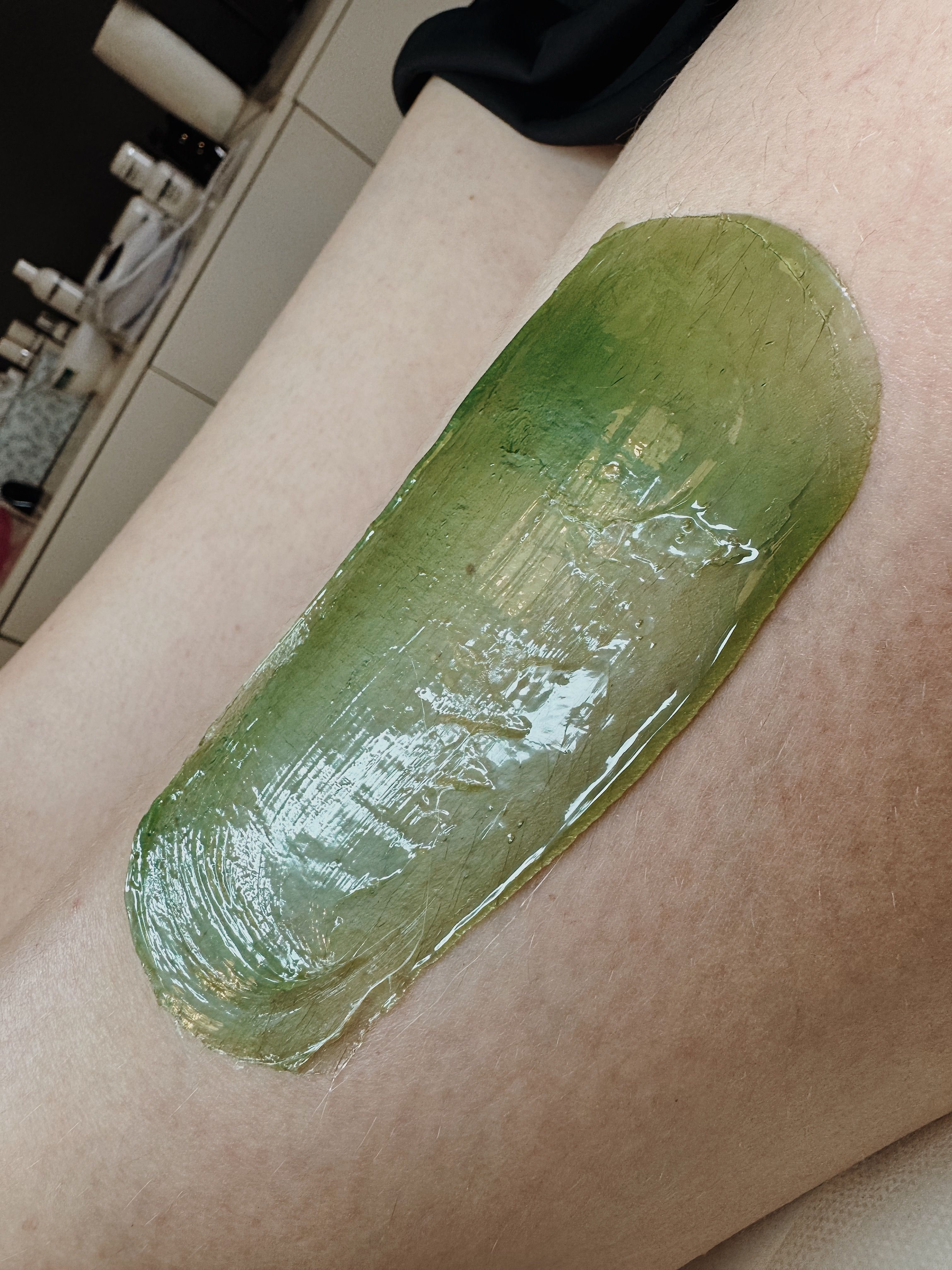green wax for hair removal on a girl's leg