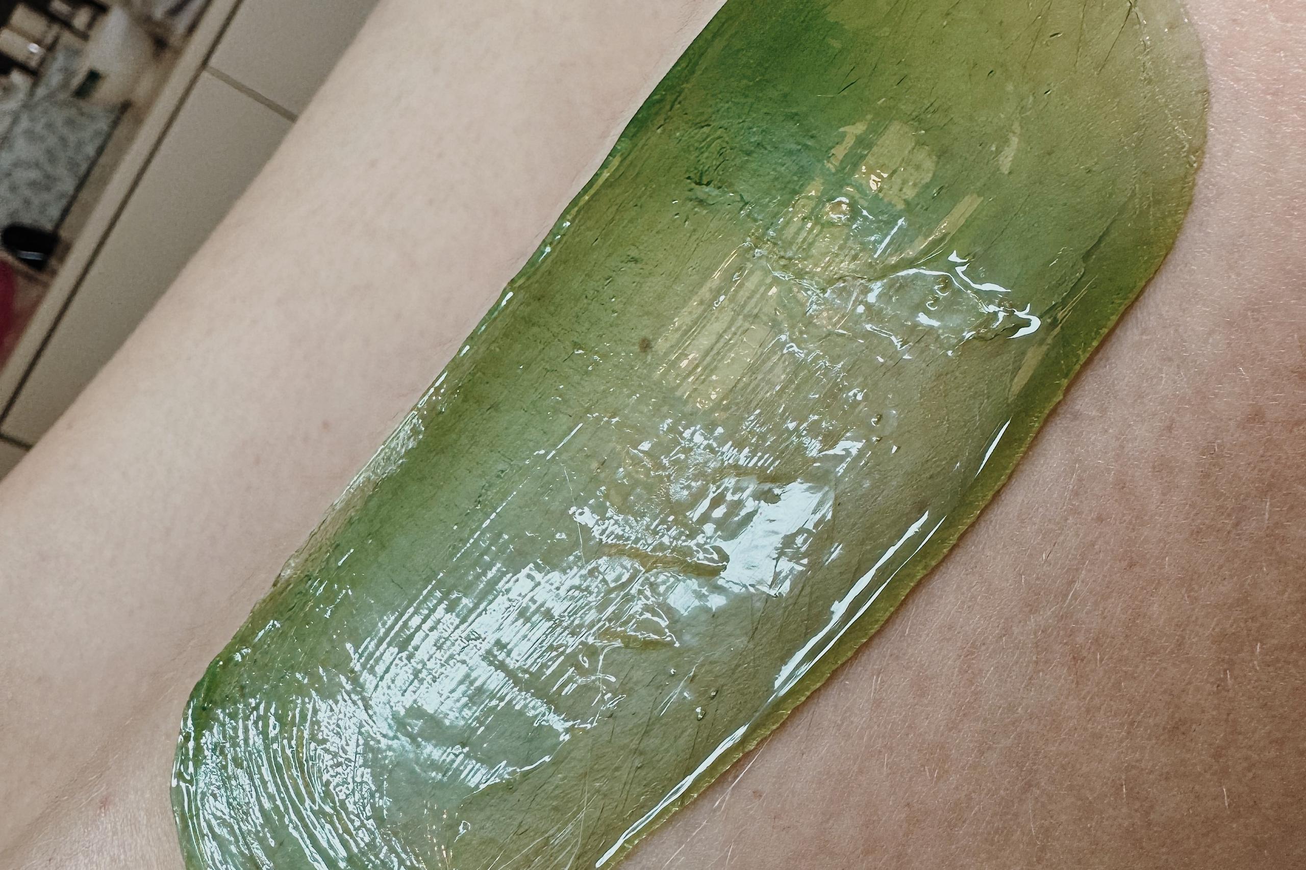 green wax for hair removal on a girl's leg