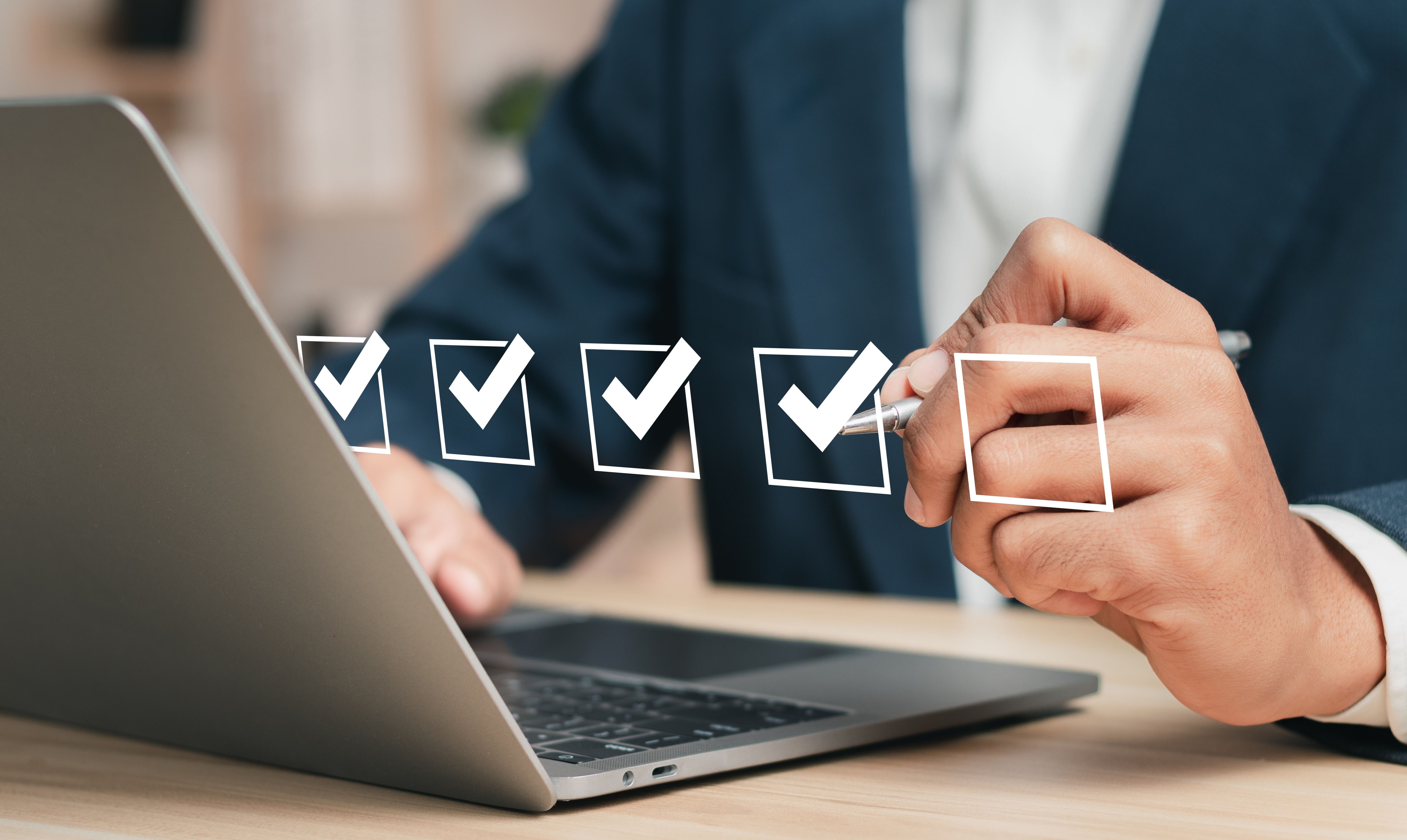 Man on a laptop with ticked off boxes