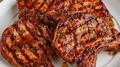 Grilled pork chops arranged on a white serving platter