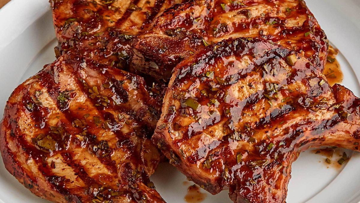 Grilled pork chops arranged on a white serving platter
