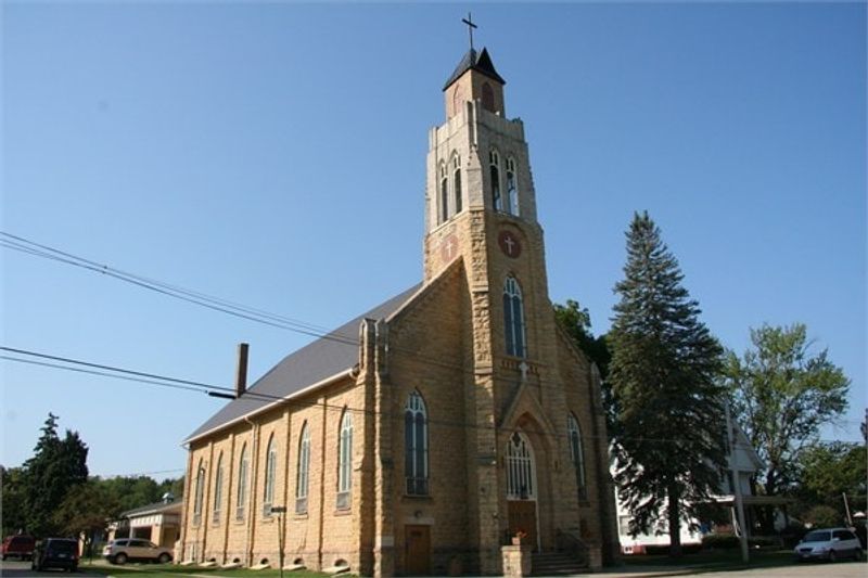 Iglesia de piedra y campanario de St. Barnabas bajo un cielo azul