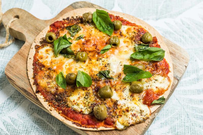 Pizza Margherita on a tortilla base with lots of cheese and olives