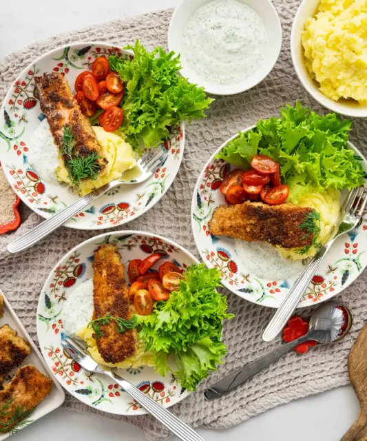 Crispy salmon pieces with dill-sour cream sauce and mashed potatoes