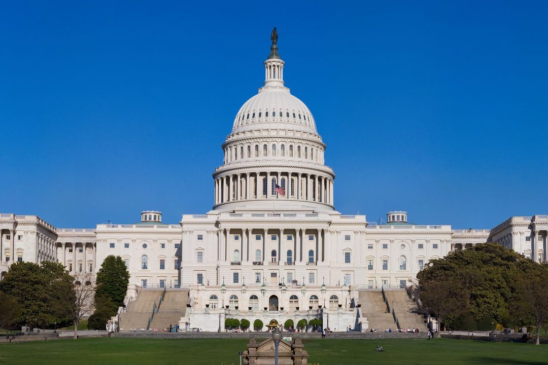 US Capitol building west front with dome under a clear blue sky