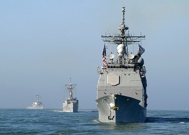 U.S. Navy and Coast Guard Ships line up in formation to parade