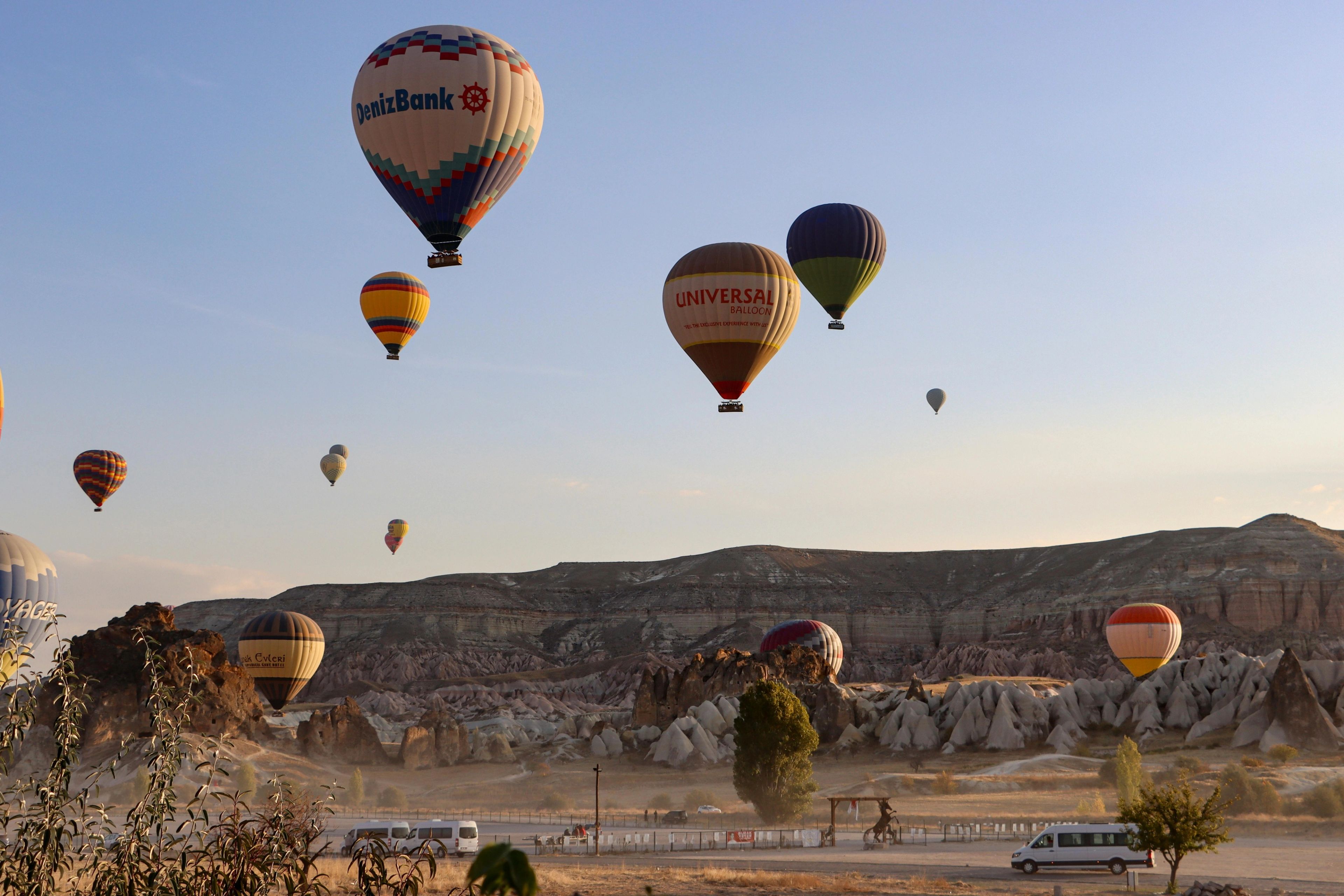 Montgolfières colorées survolant les formations rocheuses de la Cappadoce au lever du soleil