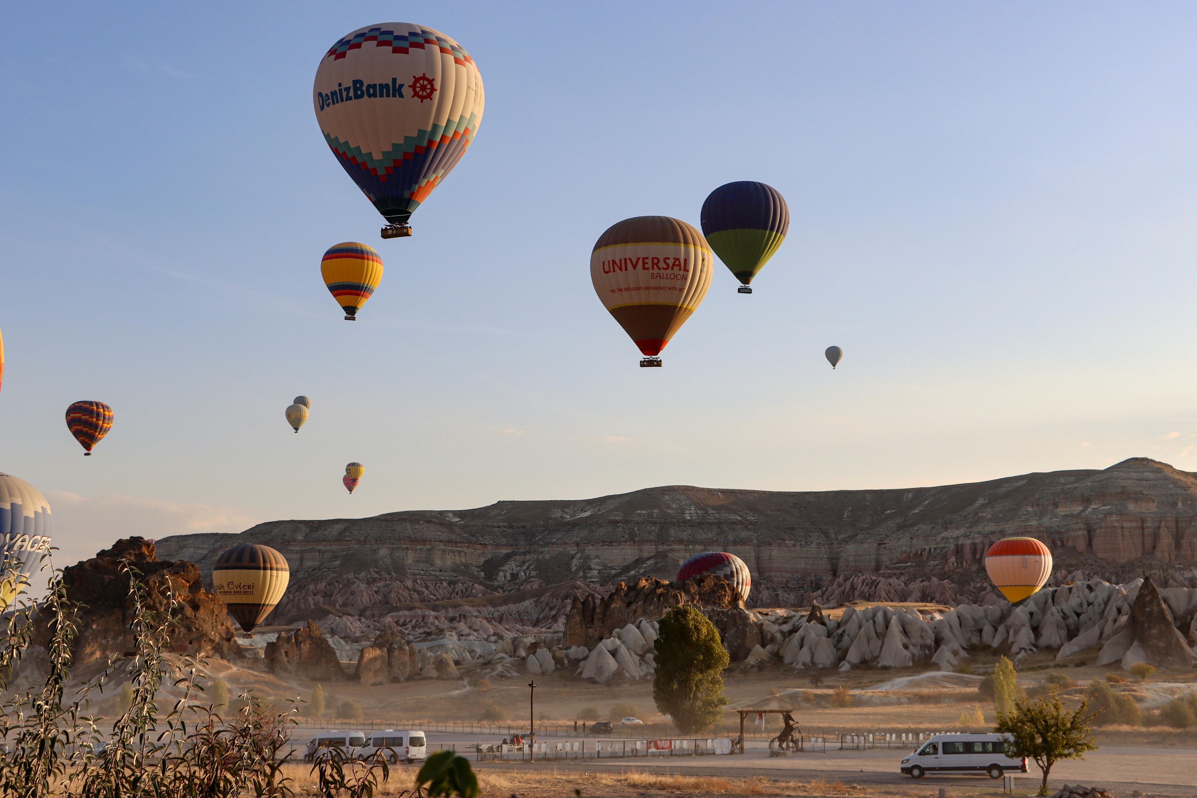 Montgolfières colorées survolant les formations rocheuses de la Cappadoce au lever du soleil