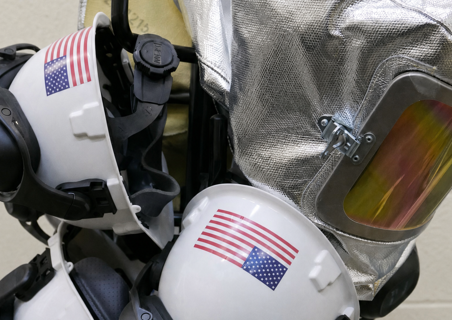 Safety helmets and a heat-protective hood on a stand