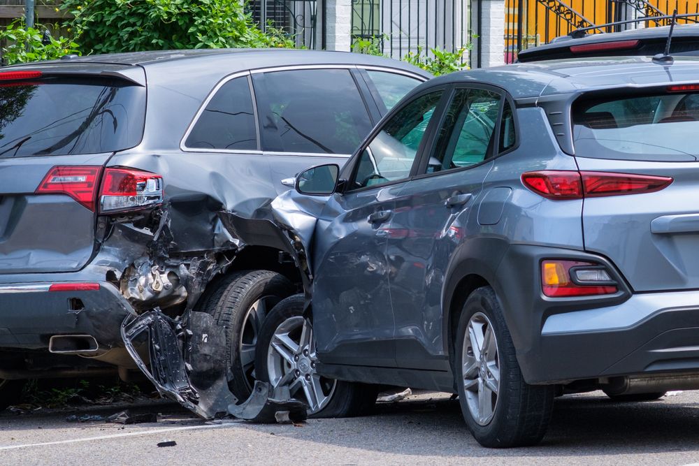 two grey cars in a car accident with damage to both vehicles