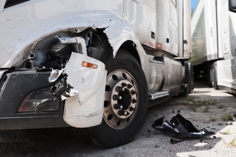 Image Semi-truck accident with damage to the cab and headlight