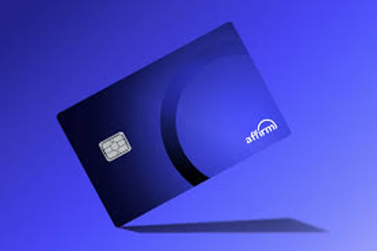 A dark blue Affirm credit card with a chip, tilted and casting a shadow on a blue background.