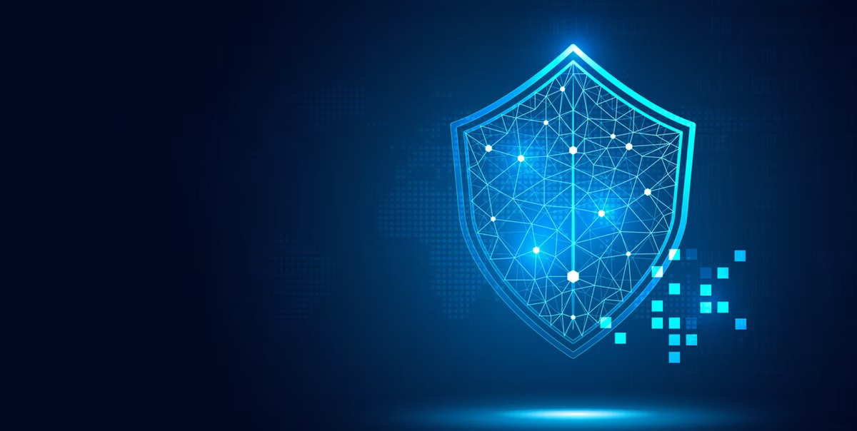 Glowing blue digital shield with network lines on a dark tech background, symbolizing cybersecurity protection