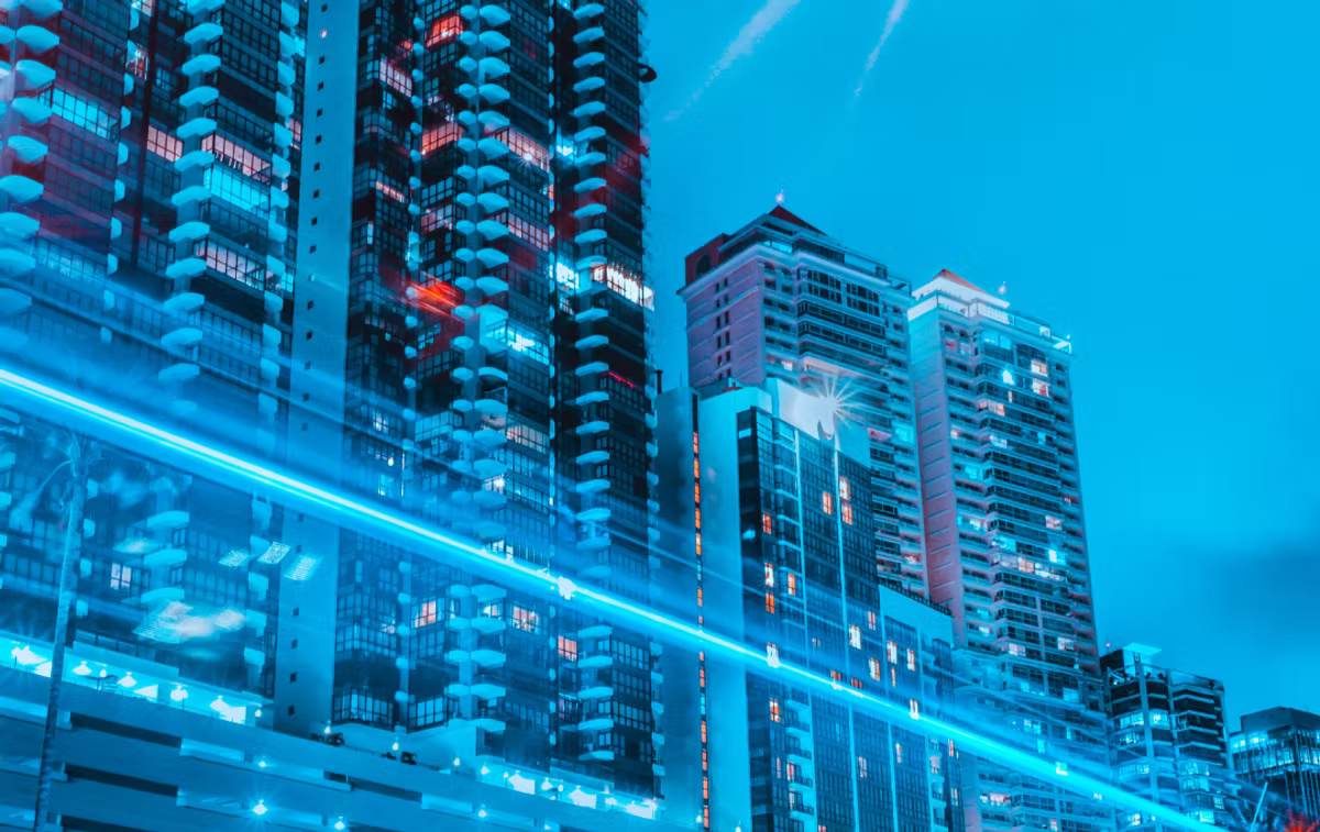 High-rise apartment towers at dusk with streaks of blue light cutting across the frame.