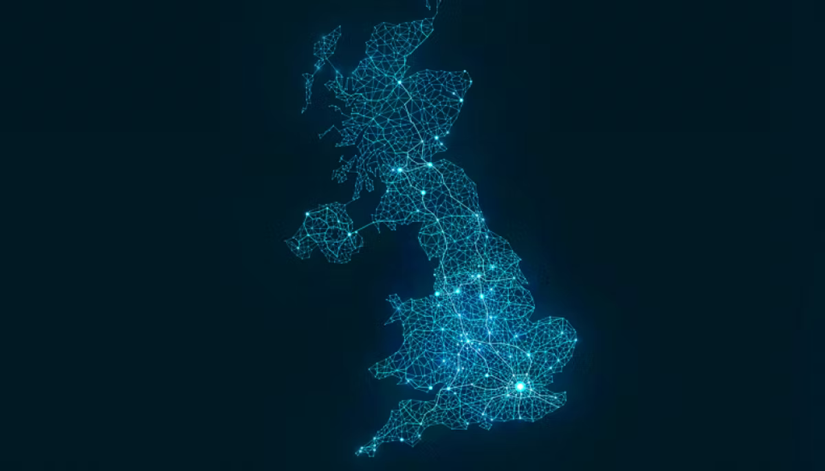A map of the United Kingdom drawn as a glowing blue wireframe mesh, brightest around the major cities, on a dark navy background.