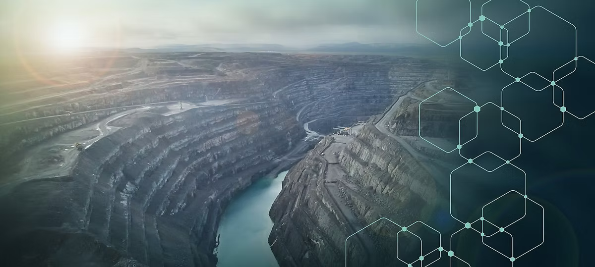 An aerial view of a vast terraced open-pit mine with turquoise water at the bottom, overlaid on the right with a pattern of linked hexagons.