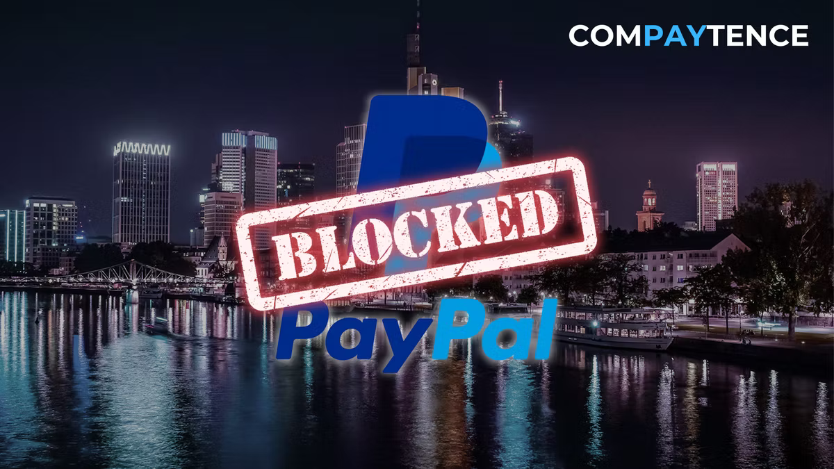 City skyline at night with "PayPal" logo and red "Blocked" stamp overlay. "COMPAYTENCE" text at the top right. Mood: restrictive.