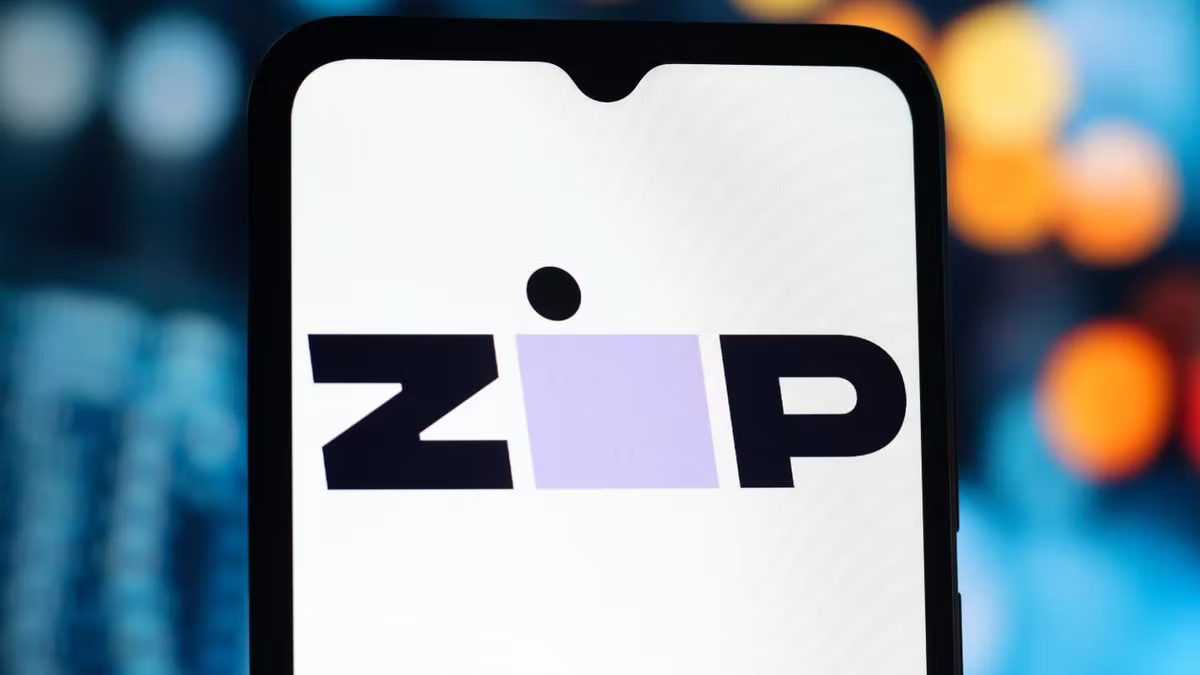 The Zip logo displayed on a smartphone screen against blurred city lights.