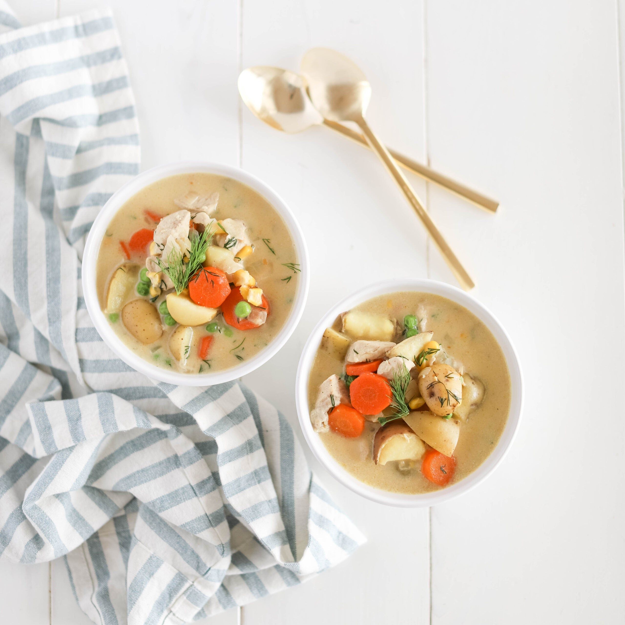 chowder in a bowl with gold spoons
