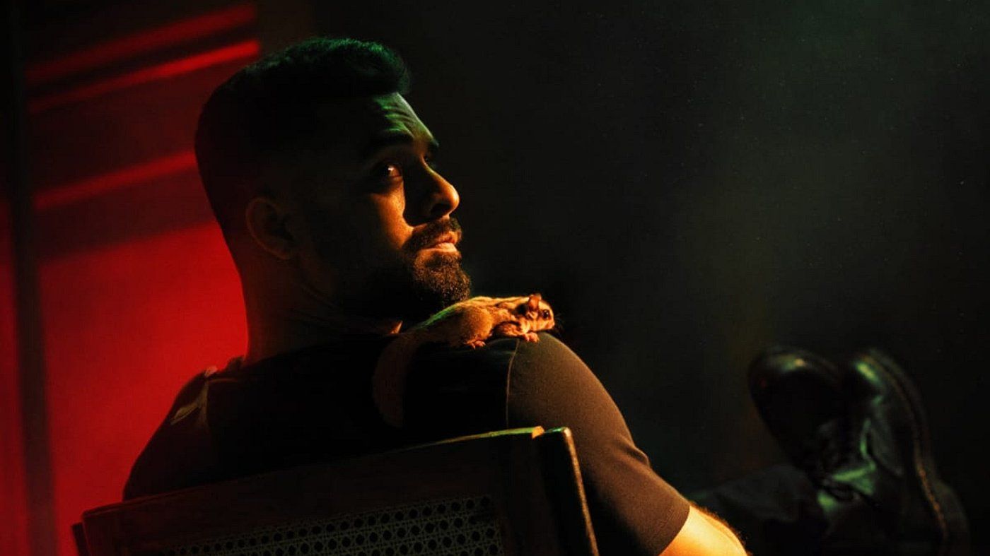 Tovino Thomas in a red-lit character poster from Bachelor Party D'eux
