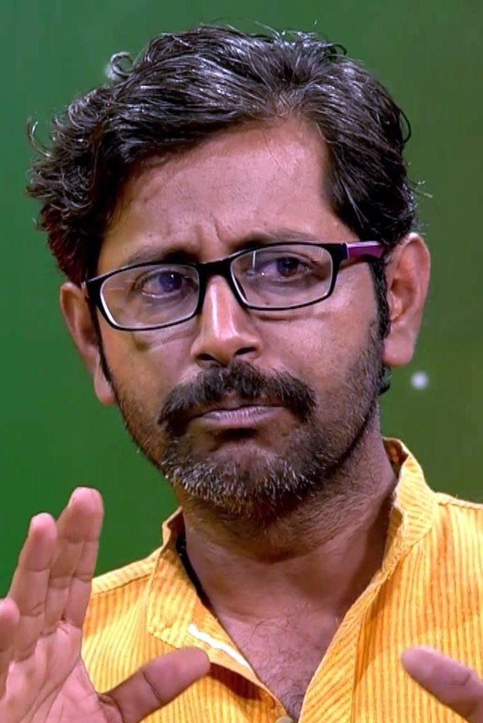 Rajesh Sharma in glasses and a yellow shirt, close-up portrait
