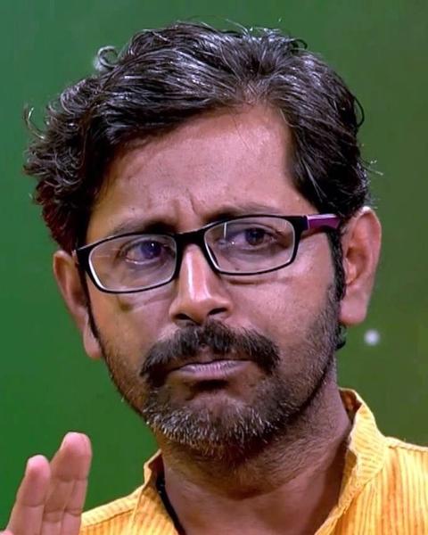 Rajesh Sharma in glasses and a yellow shirt, close-up portrait