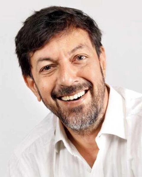 Rajat Kapoor smiling in a white shirt, close-up portrait