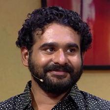 Sidharth Bharathan with curly hair and a beard at an event