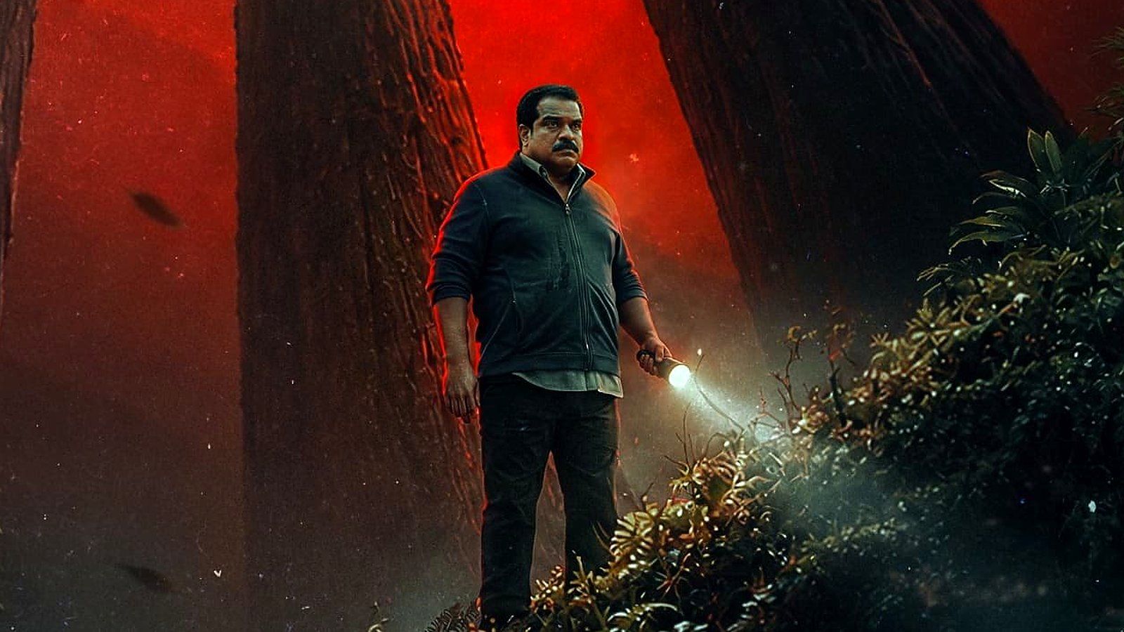 Dileesh Pothan holding a torch under a red sky in the new Bouma poster