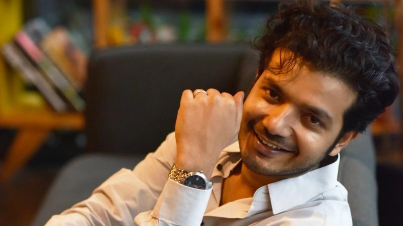 Sreenath Bhasi smiling in a white shirt