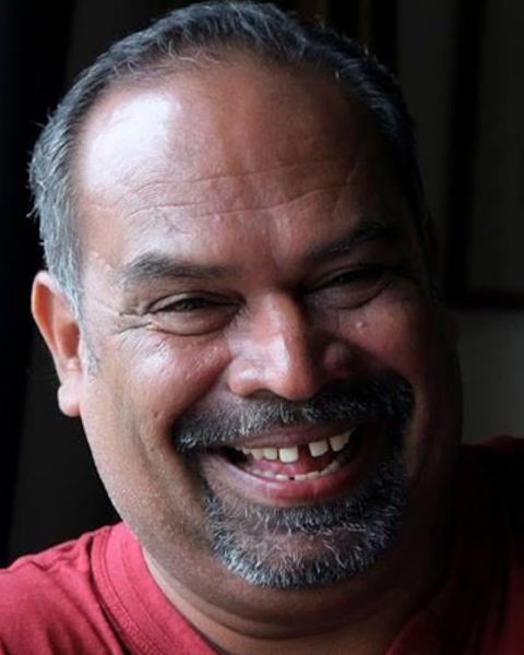 Alencier Ley Lopez in a red shirt, laughing, close portrait