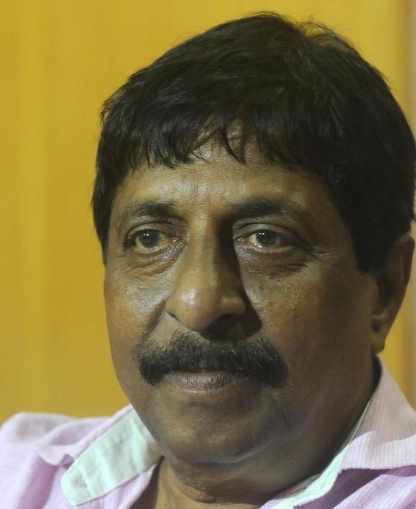Sreenivasan with a moustache looking at the camera, close-up portrait