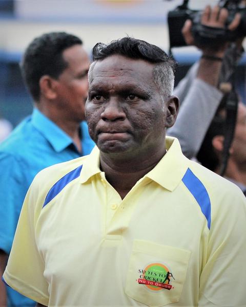 I. M. Vijayan in a yellow polo shirt among people outdoors