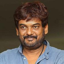 Puri Jagannadh with arms crossed in a blue linen shirt, smiling