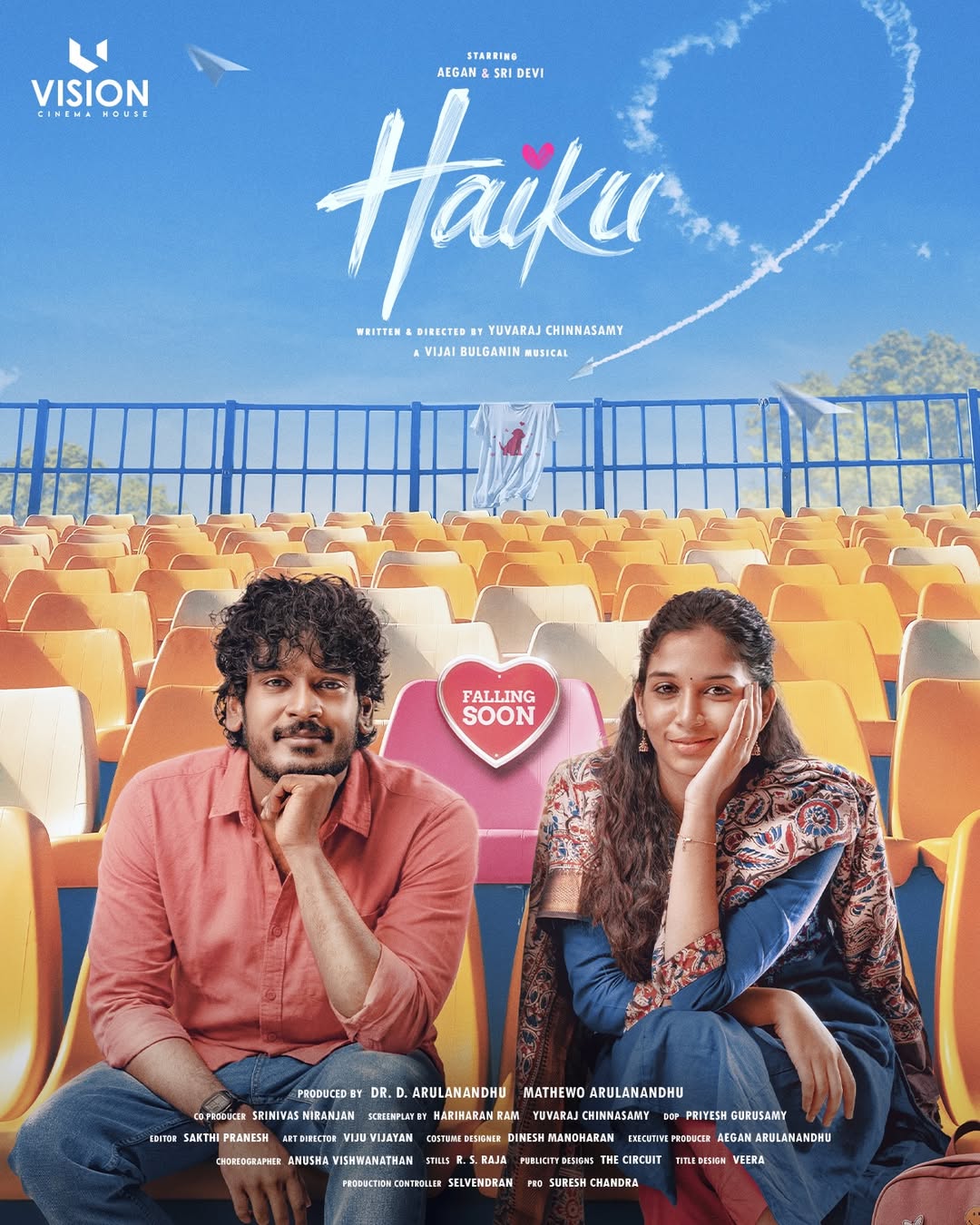 Haiku poster with Aegan in a coral shirt and Sri Devi Apalla in a blue salwar seated in empty orange stadium seats