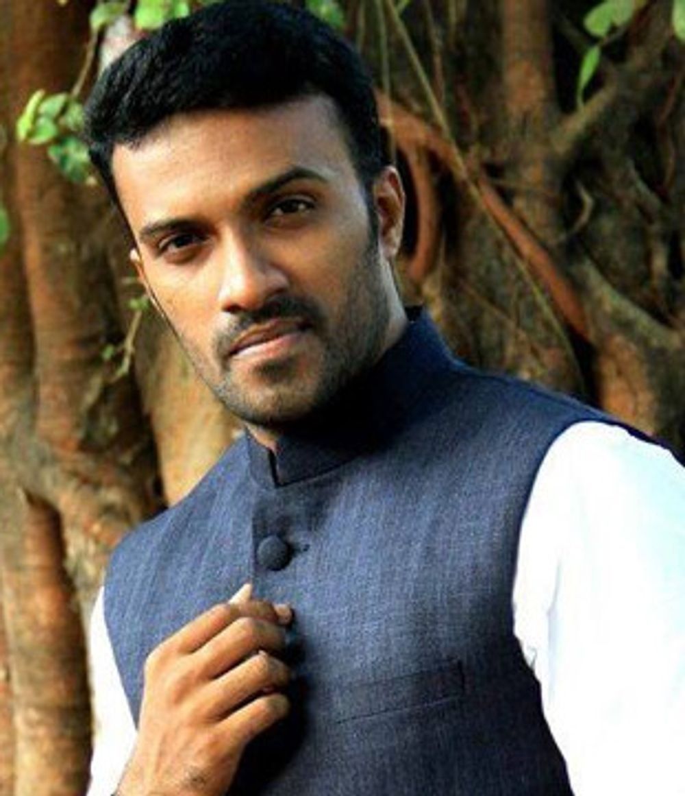 Rahul Rajagopal in a blue bandhgala waistcoat over a white kurta, standing by a tree