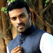 Rahul Rajagopal in a blue bandhgala waistcoat over a white kurta, standing by a tree