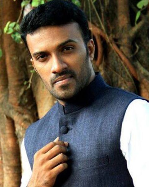 Rahul Rajagopal in a blue bandhgala waistcoat over a white kurta, standing by a tree