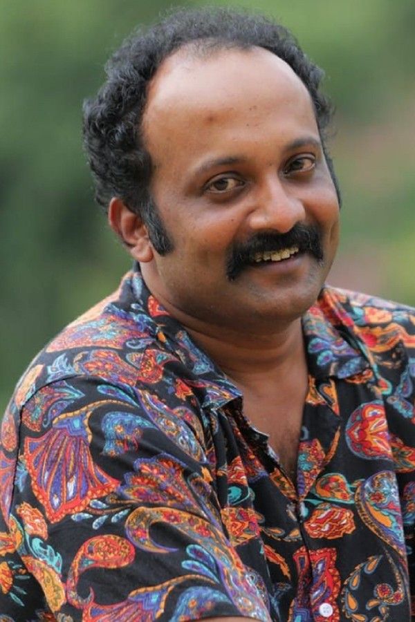 Jibin Gopinath with a moustache in a patterned shirt, smiling