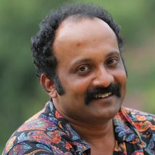 Jibin Gopinath with a moustache in a patterned shirt, smiling
