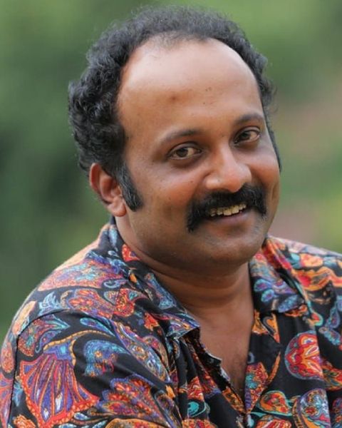 Jibin Gopinath with a moustache in a patterned shirt, smiling
