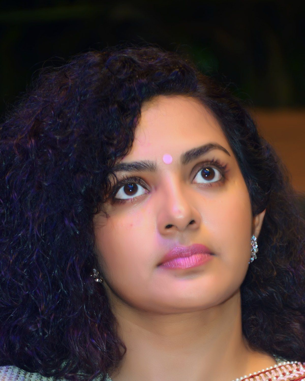 Parvathy Thiruvothu with curly hair and a bindi, close-up portrait