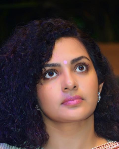 Parvathy Thiruvothu with curly hair and a bindi, close-up portrait