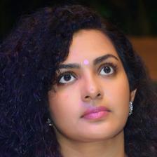 Parvathy Thiruvothu with curly hair and a bindi, close-up portrait